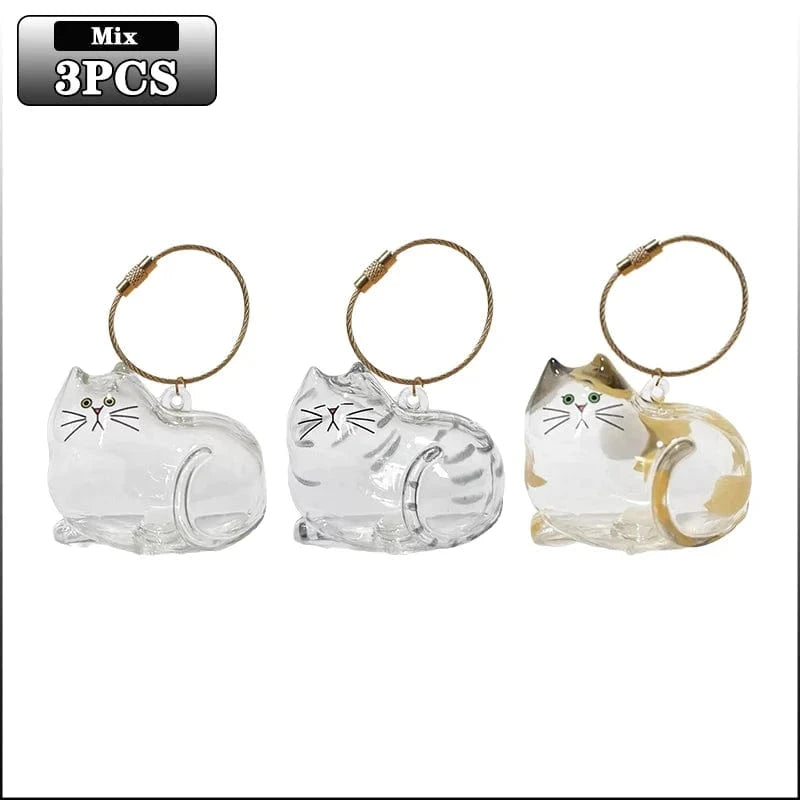 Three cat-shaped keychains with gold accents on a white background