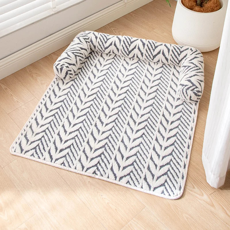 Patterned rug on a wooden floor with a plant in the background