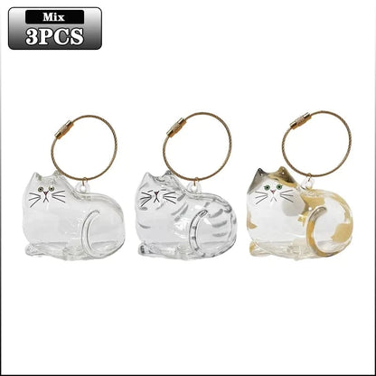 Three cat-shaped keychains with gold accents on a white background