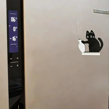Fridge door with a decorative sticker of a black cat holding a white vase.
