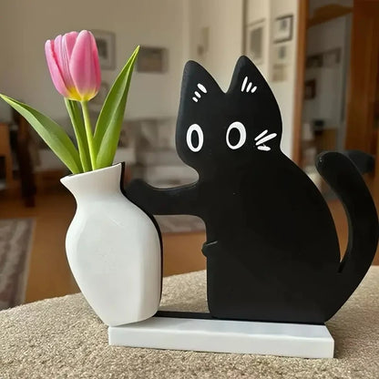 Black cat-shaped lamp with a white vase holding pink tulips on a table.