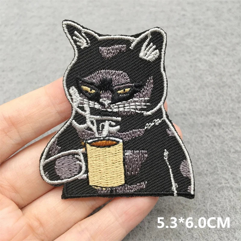 Embroidered patch of a cat holding a coffee cup on a hand, with dimensions 5.3*6.0CM.