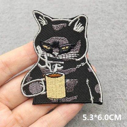 Embroidered patch of a cat holding a coffee cup on a hand, with dimensions 5.3*6.0CM.