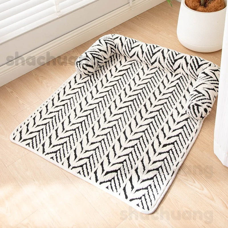 Black and white patterned rug on a wooden floor with a plant in the background