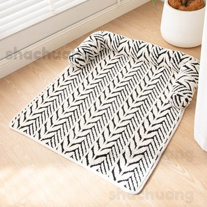 Black and white patterned rug on a wooden floor with a plant in the background