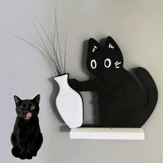 Black cat figurine interacting with a white vase on a shelf against a plain wall.