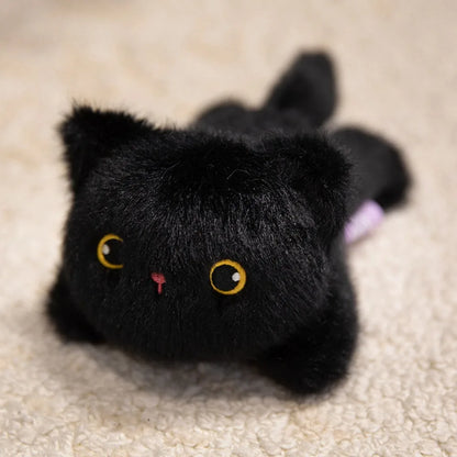 Black plush cat toy with yellow eyes and a pink nose on a beige carpet