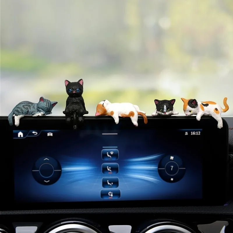 Car dashboard with toy cats on a blurred outdoor background