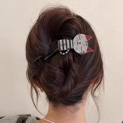 Cat-shaped hair clip in a person's hair against a neutral background