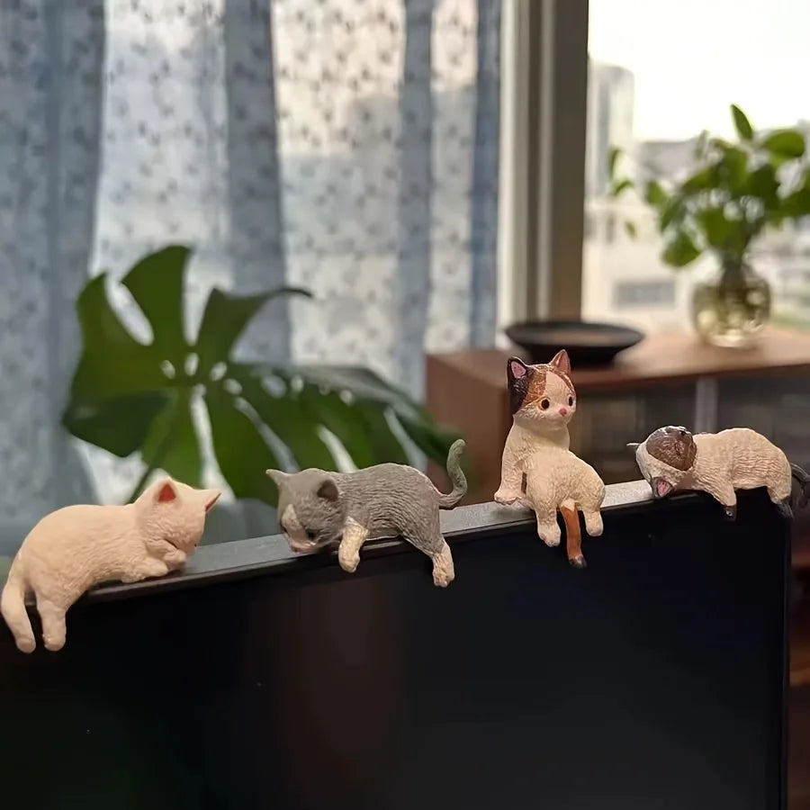 Cat figurines on a surface with a blurred indoor background