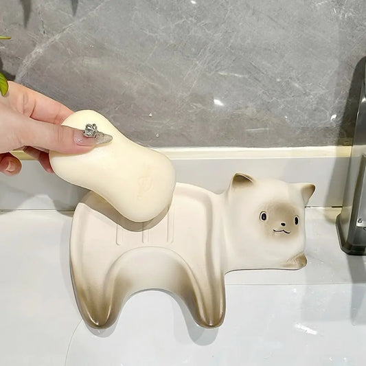 Hand holding a white bear-shaped soap on a marble countertop
