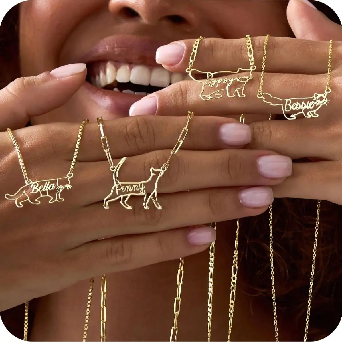 Gold necklaces with cat designs and names on a blurred background
