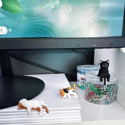 Desk setup with computer monitor, figurines, and stationery items.
