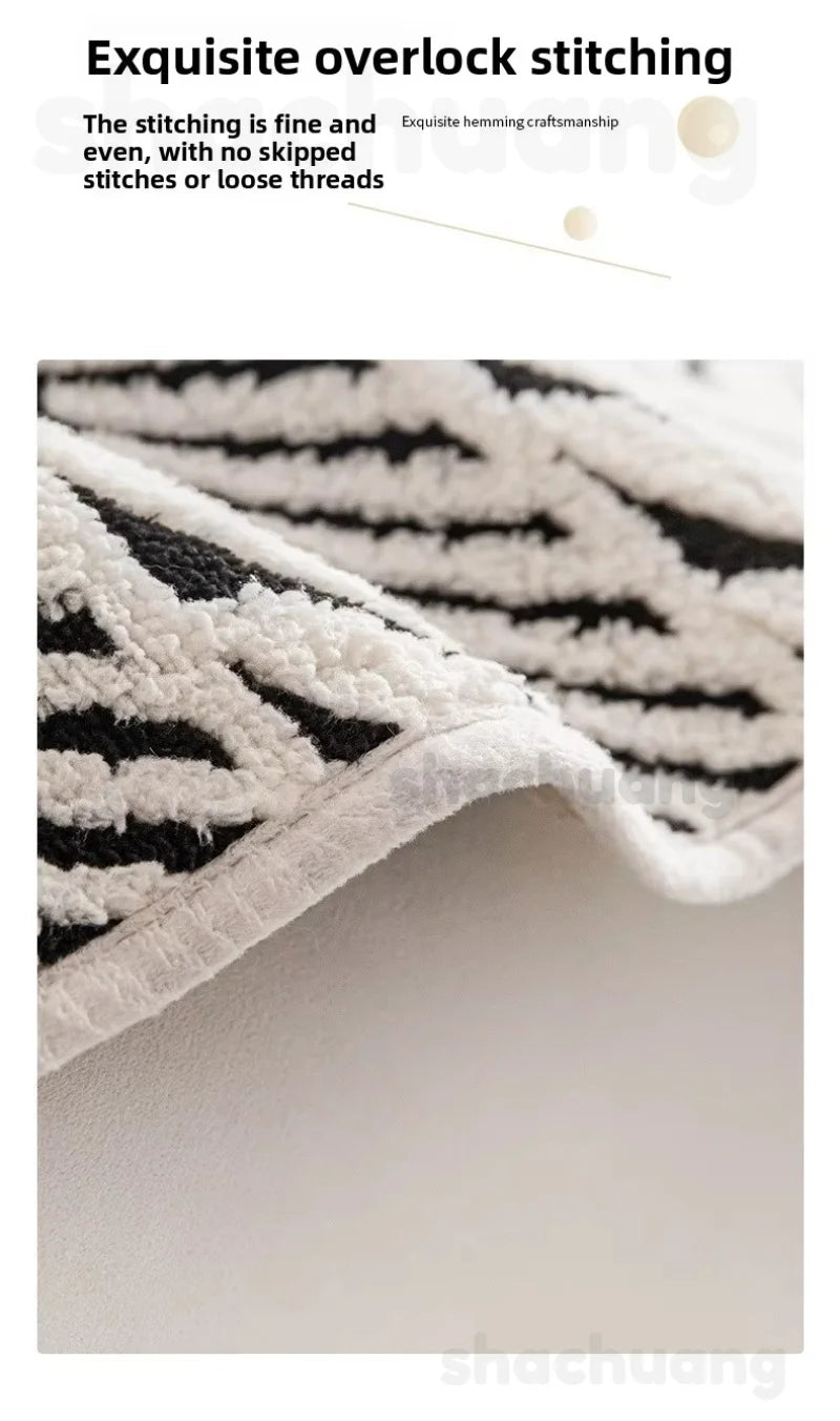 Close-up of a textured rug with black and white pattern, highlighting stitching quality.