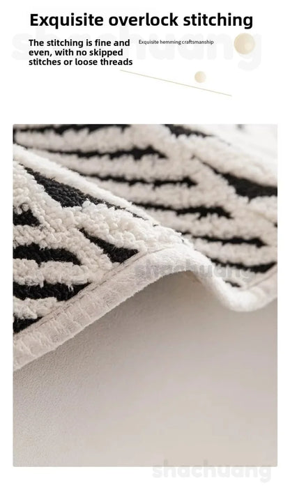 Close-up of a textured rug with black and white pattern, highlighting stitching quality.