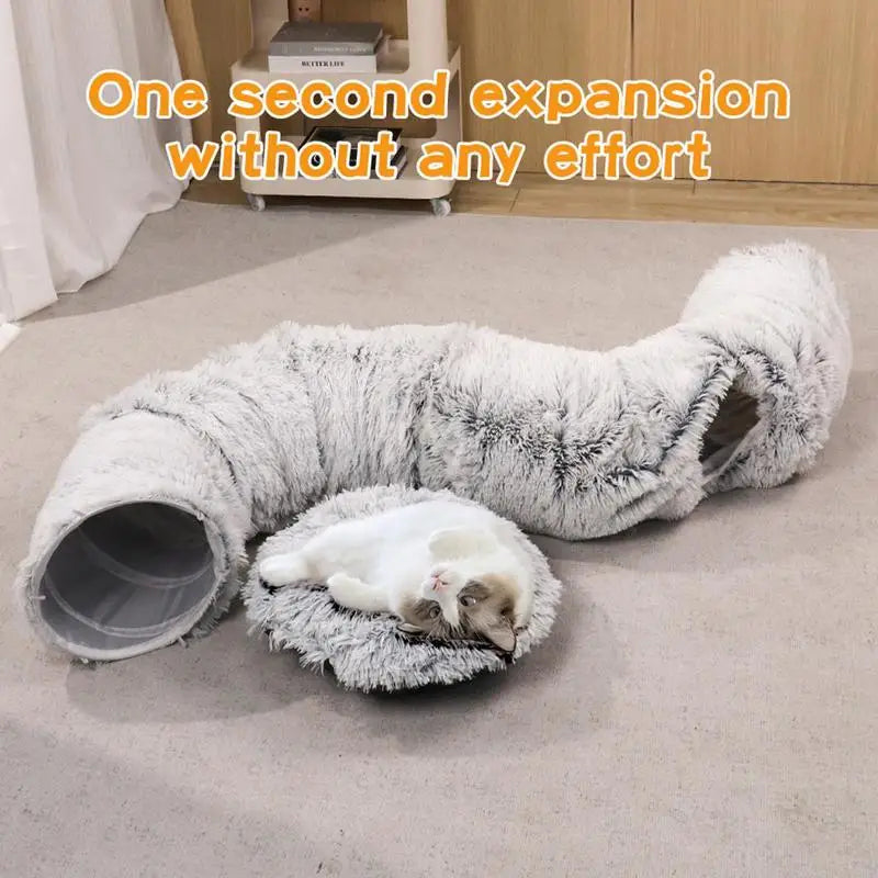 Fluffy cat tunnel with a cat lying on a cushion on a carpeted floor.