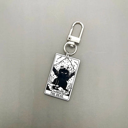 A collection of acrylic keychains featuring black and white tarot card designs with cat imagery.