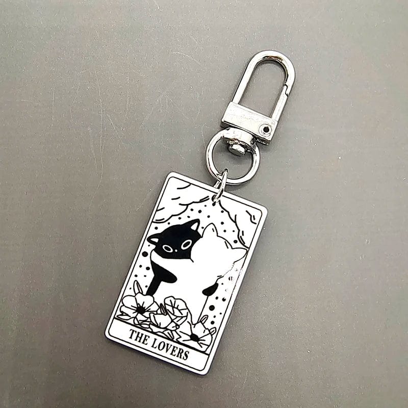 A collection of acrylic keychains featuring black and white tarot card designs with cat imagery.