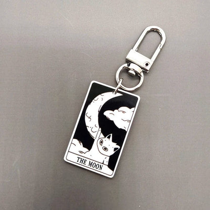 A collection of acrylic keychains featuring black and white tarot card designs with cat imagery.