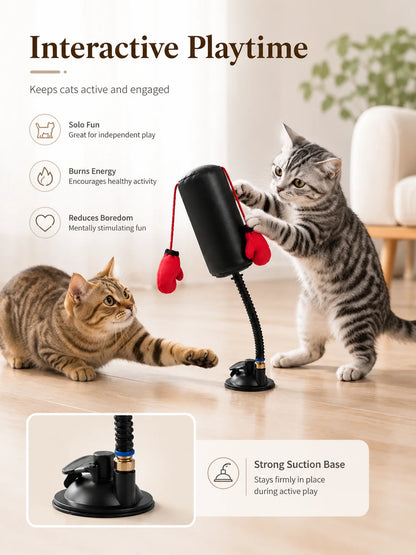 Two cats playing with a cat toy on a wooden floor.