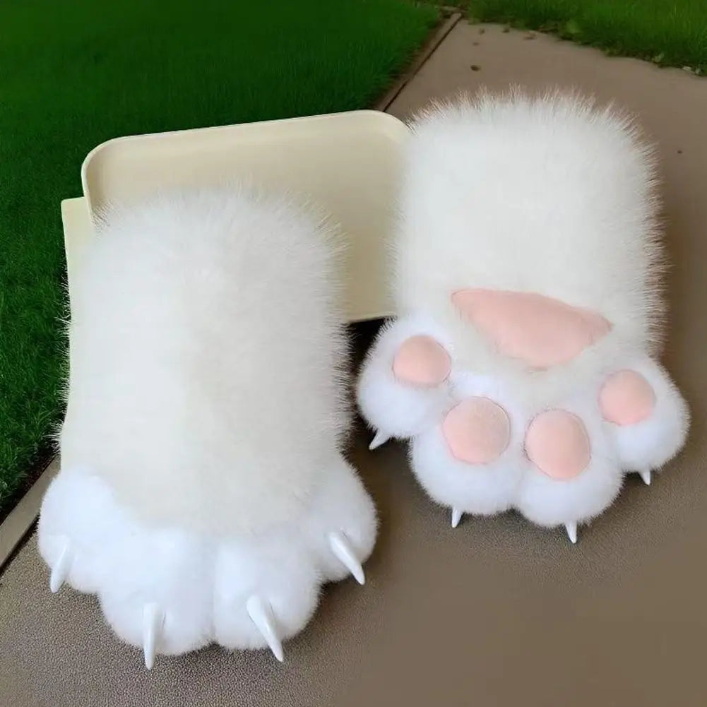 Pair of fluffy white paw-shaped gloves with pink pads on a green grass background