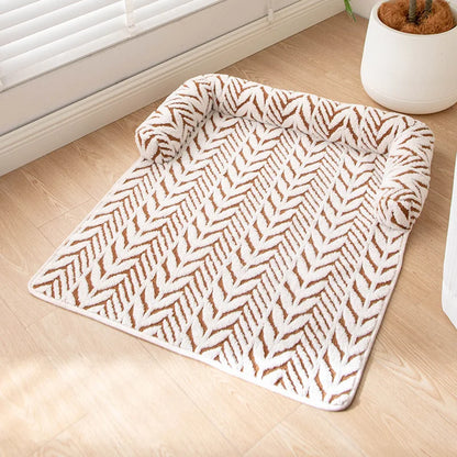 Patterned rug on a wooden floor with a plant in the background