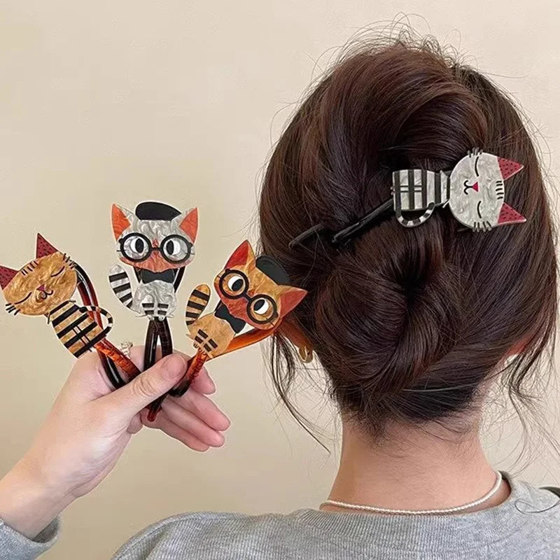 Person styling hair with cat-themed hair clips against a beige background