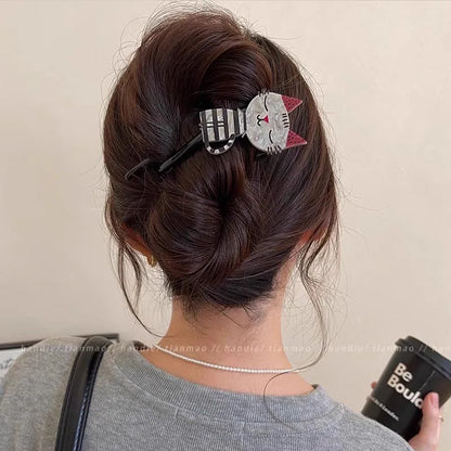 Person with a cat-shaped hair clip in their hair, holding a coffee cup.