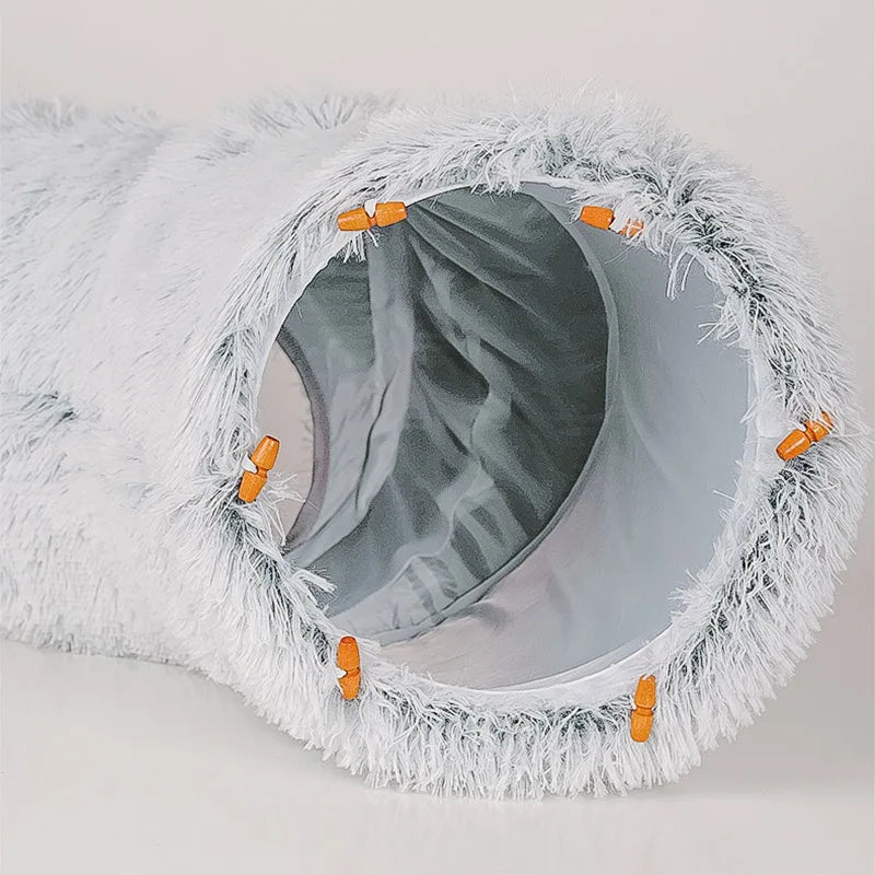 Pet play tunnel with white fur and orange buttons on a light gray background
