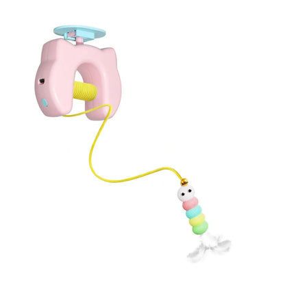 Pink toy with a yellow string and colorful bead charm on a white background