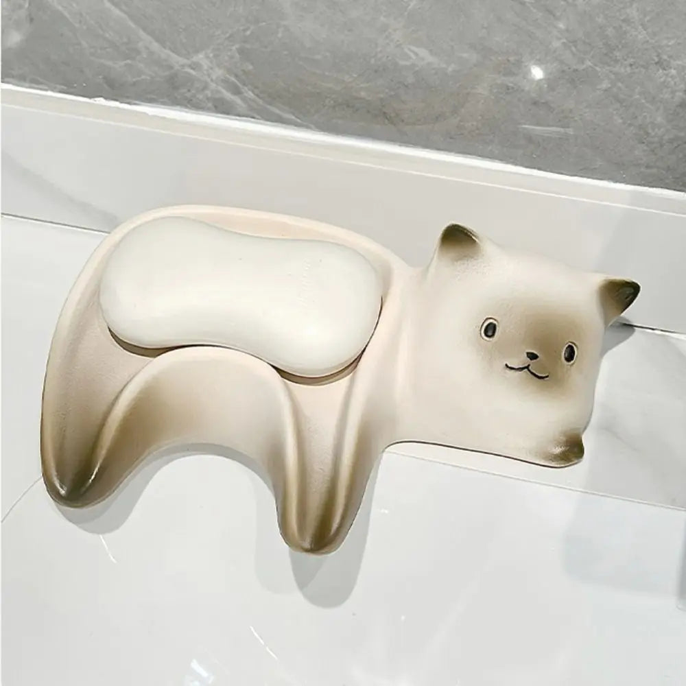 Ceramic bear-shaped soap dish on a tiled bathroom wall.