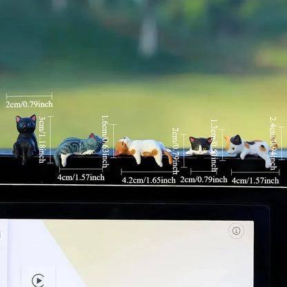 Small cat figurines with measurements against a blurred natural background