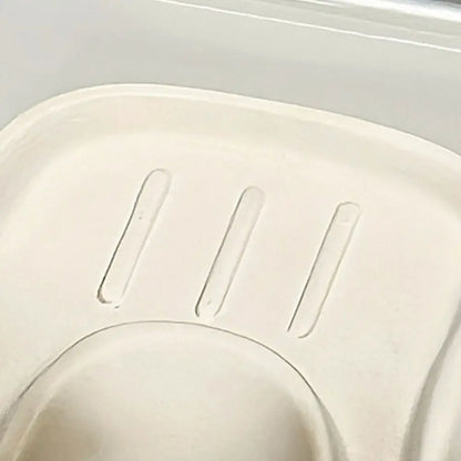 Close-up of a white plastic component with engraved lines on a light gray background