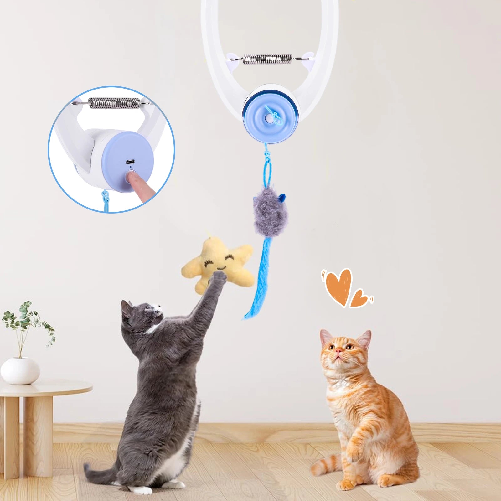 Two cats playing with a hanging pet toy featuring stars and a heart.