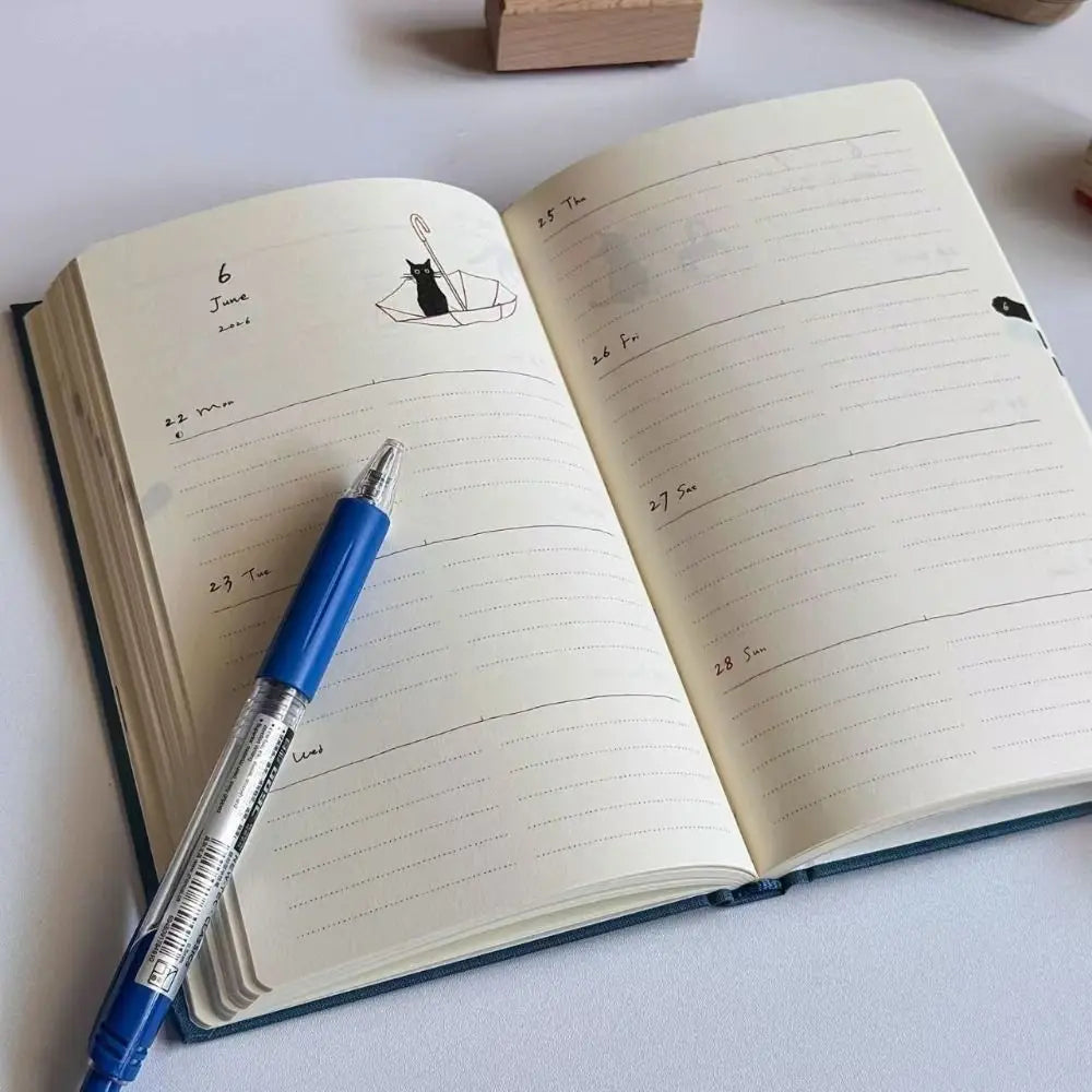 Open notebook with lined pages and a blue pen on a light surface