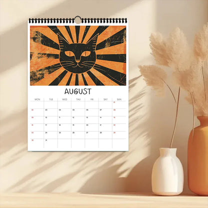 Calendar with a cat design for August on a wooden surface with decorative vases.