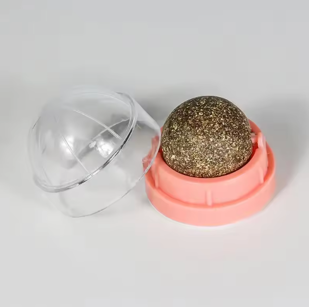 Gold glittery sphere in a clear plastic dome on a light gray background