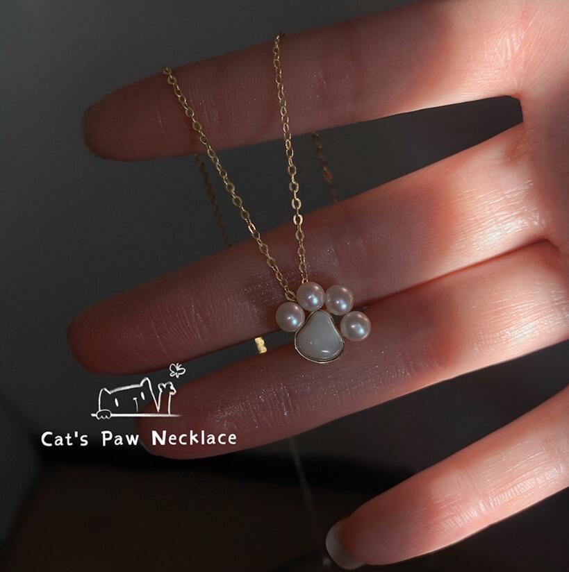 Delicate Paw Pearl Pendant Close-Up on Hand